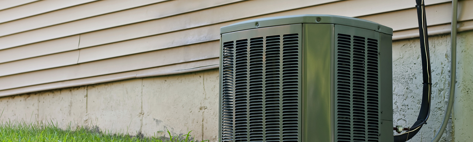 A residential central air conditioning unit sitting outside a home used for regulating the homes AC to a comfortable level.