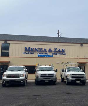 front of Menza and Zak building with 3 trucks backed into the parking lot